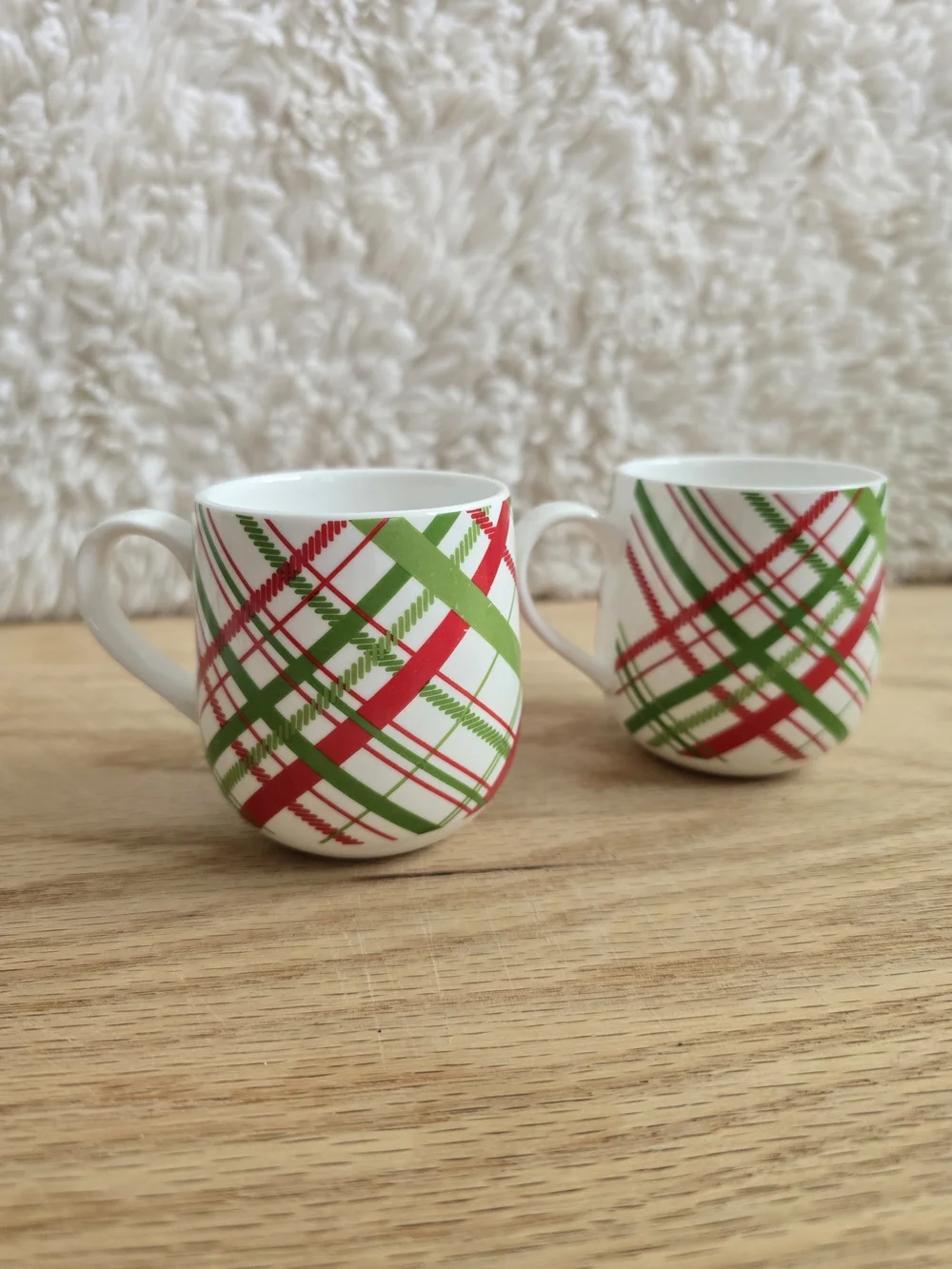 Crate & Barrel brand holiday mugs featuring a red and green plaid pattern
